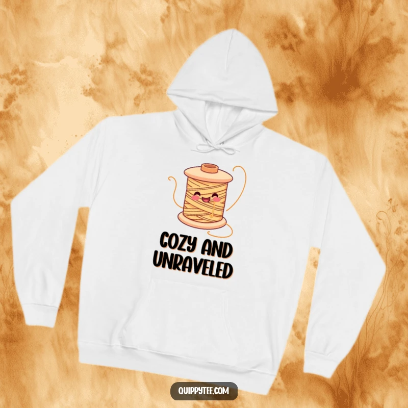 Funny hoodie showcasing a smiling spool of thread character joyfully unwinding, perfect for cozy crafting sessions.